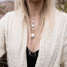 A trio of Champers Necklaces worn on model, Ti in the middle.