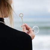 Blowing bubbles with Bubbles Royale Bubble Wand Necklace